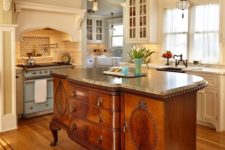 25 an antique French cabinet with a granite counter used as a kitchen island