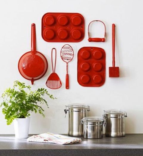 red reclaimed utensils on a kitchen wall will catch an eye and look super cute
