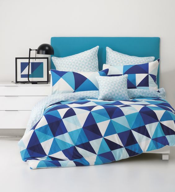 bold blue, navy and white triangle print bedding for a seaside space