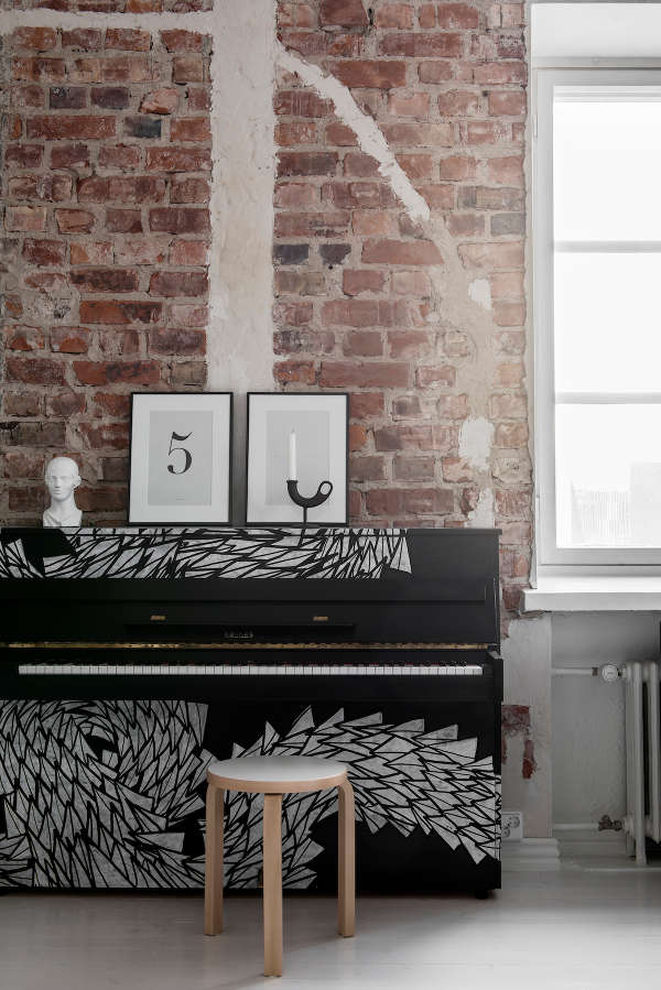 The piano in the living room is styled to minimalism with its black and painted white decor