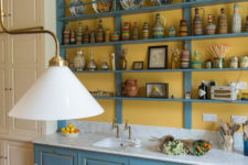 04 The kitchen countertop is clad with white marble, and the lamps are vintage brass ones