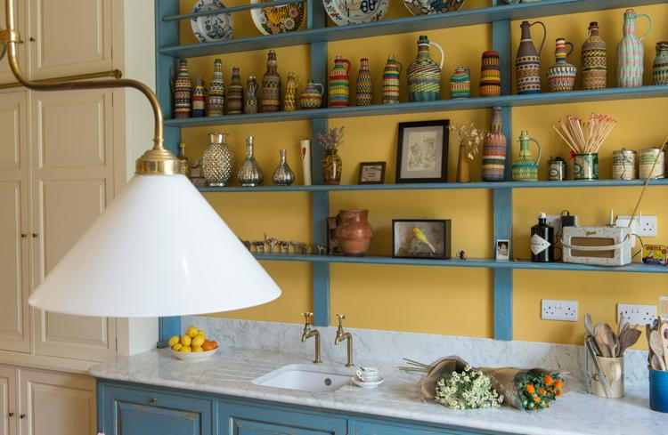 The kitchen countertop is clad with white marble, and the lamps are vintage brass ones