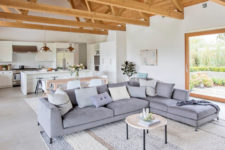 04 The living space features a large corner grey sofa, a comfy rug and those wooden beams on the ceiling add coziness