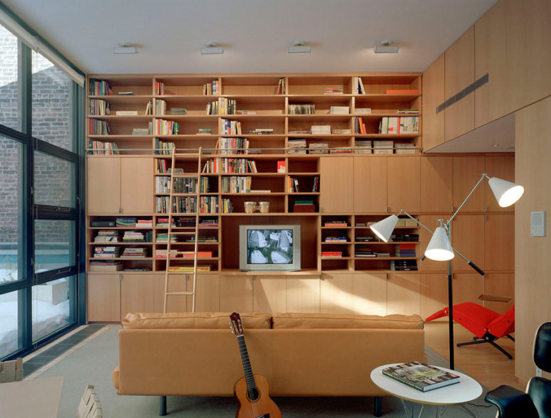 There's a library, fully decorated with light-colored wood, which makes it cozy and inviting, and there's a beige leather sofa