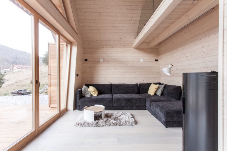 A glazed wall brings much natural light in and makes the interiors connected to the outdoor spaces