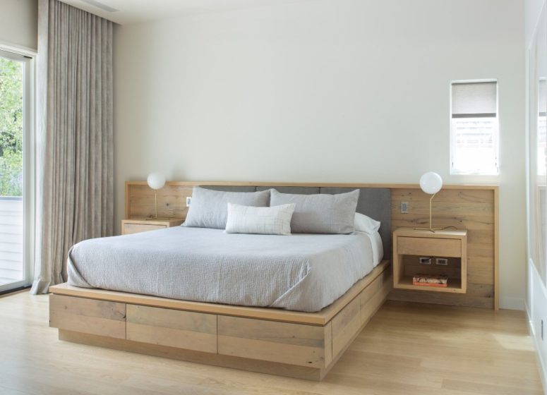 The master bedroom is modern and almost minimalist, with light-colored wooden platform bed and floating nightstands