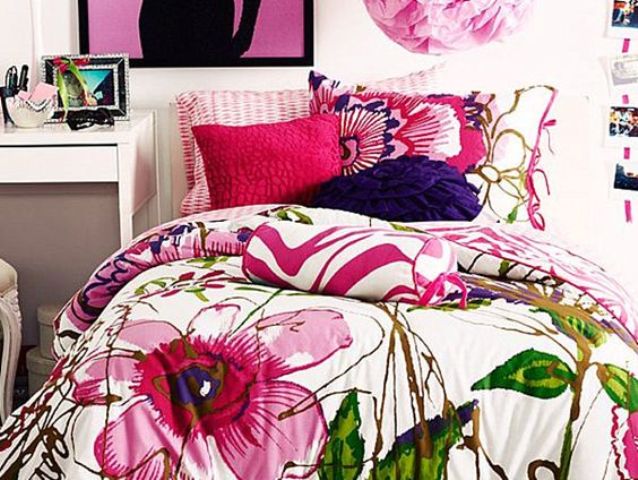 bold bedding in pink, green and purple with colorful pillowcases