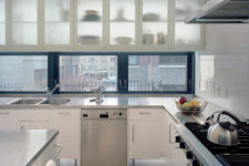 06 The kitchen is light-filled and spacious, with silver and white cabinets and steel surfaces