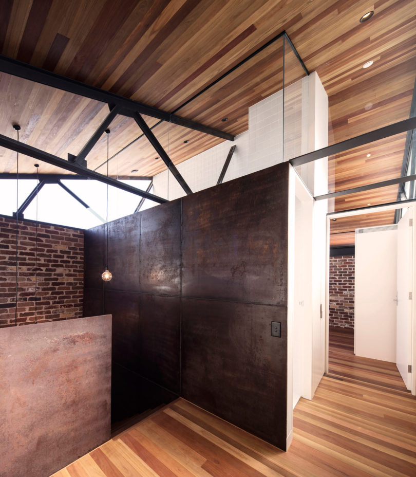 The shower has brick walls and rough metal dark ones, the industrial decor is perfectly shown here