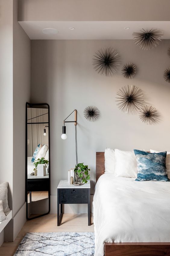 the master bedroom is personalized with unique wall decor and industrial wall lamps
