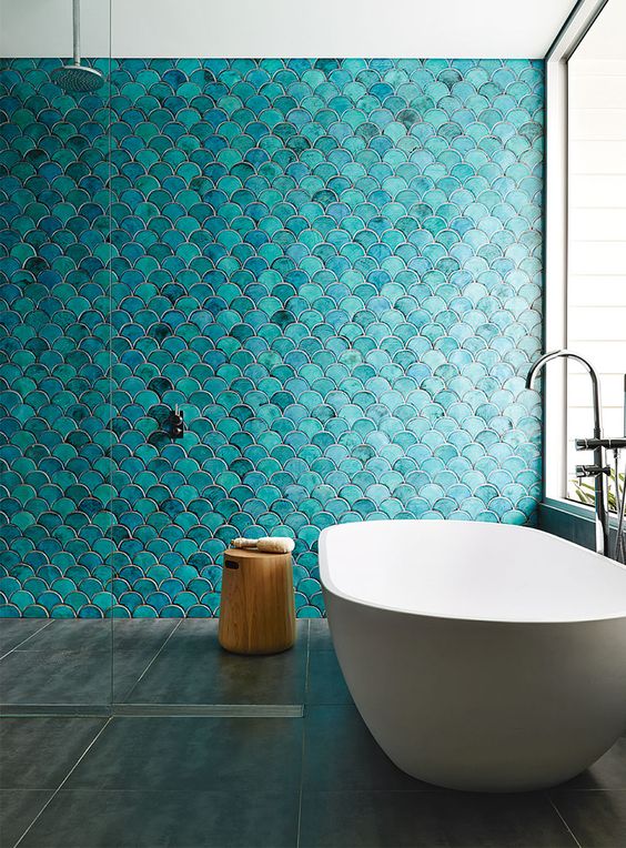 Turquoise fish scales make a bathroom super eye catchy, and a white bathtub is very contrating