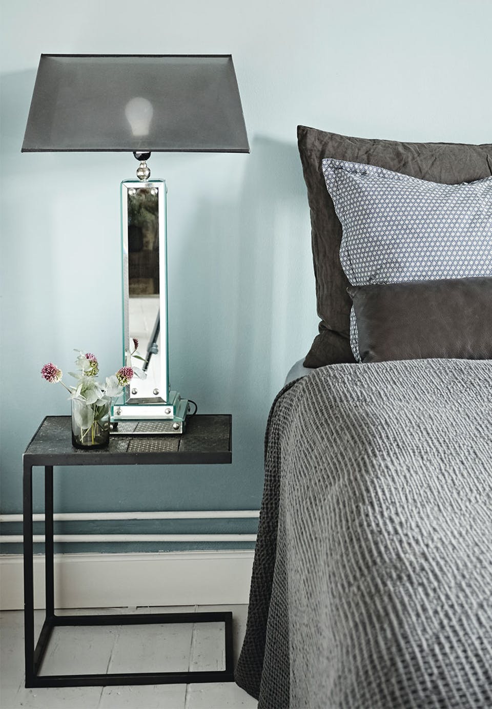 The bedroom is done in dove grey, with grey and black touches, mirror and metal are used to give it a modern and fresh feel