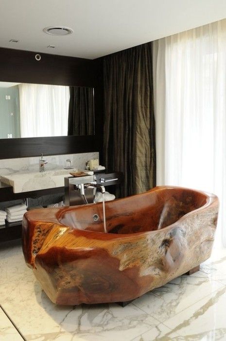 a rough carved stone bathroom makes a bold statement in this elegant marble bathroom