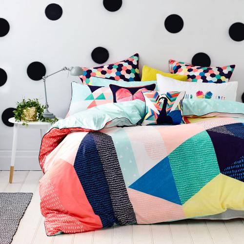 colorful hexagon print pillows and a bold duvet with colorful geo figures on it