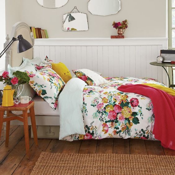 red and yellow floral bedding with accnet pillows and blankets in matching colors