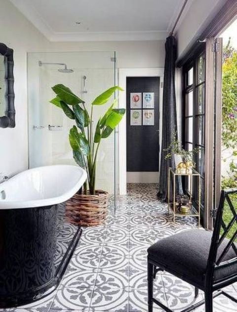 a palm tree in a woven pot enlivens a black and white bathroom