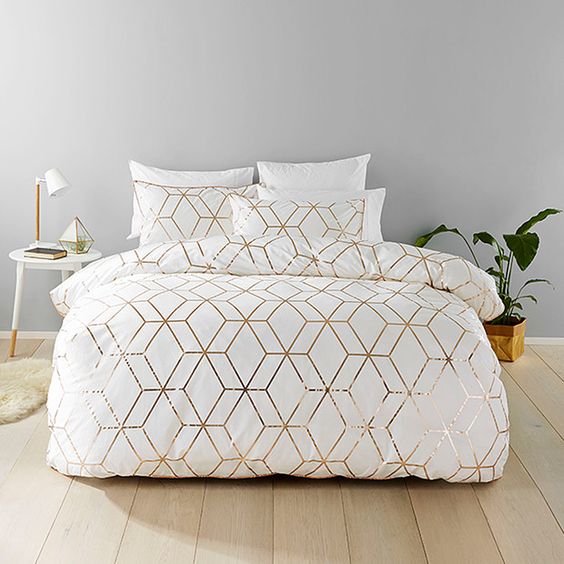 chic white bedding with geometric gold prints for an elegant and glam bedroom