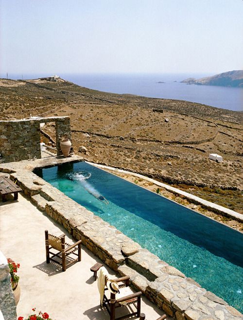 Nature inspired stone clad narrow pool with a view to the desert and sea