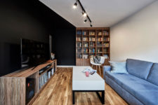 01 This compact Polish apartment is done in black and white with warm-colored wooden touches that make it cozier and welcoming