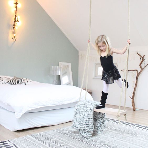 a swing in a serene and light-colored girl's room is a storage piece and a play piece in one