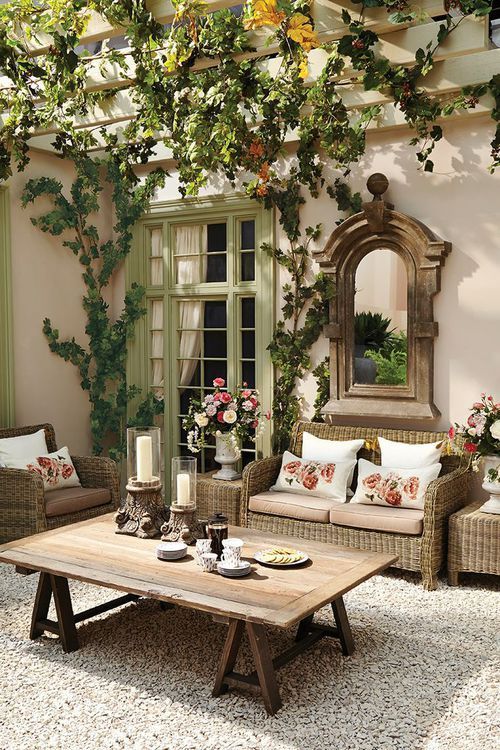 a patio that resembles a traditional living room with vintage touches and rustic furniture