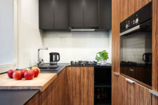 05 The kitchen is also small, it features white walls and a backsplash and black and warm wood cabinets for a contrasting look