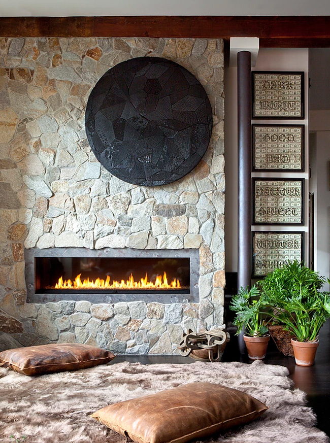 There's a fireplace built-in a wall covered with real stone, here there's a fluffy rug and pilloows to enjoy it