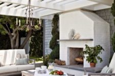 05 a coastal-inspired outdoor living room with a chandelier and a fireplace and neutral upholstery