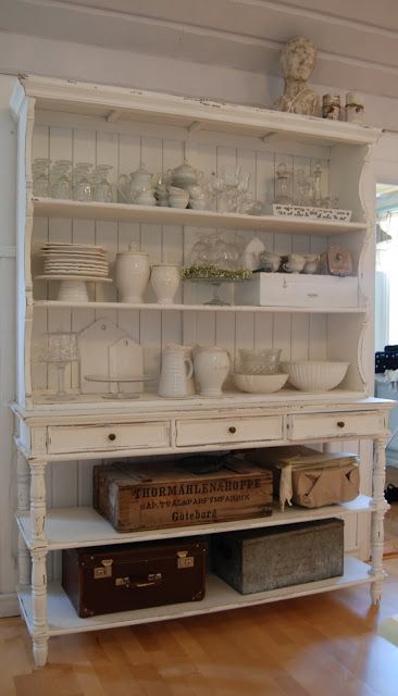 a white shabby chic cupboard without glass parts accomodates a lot of things