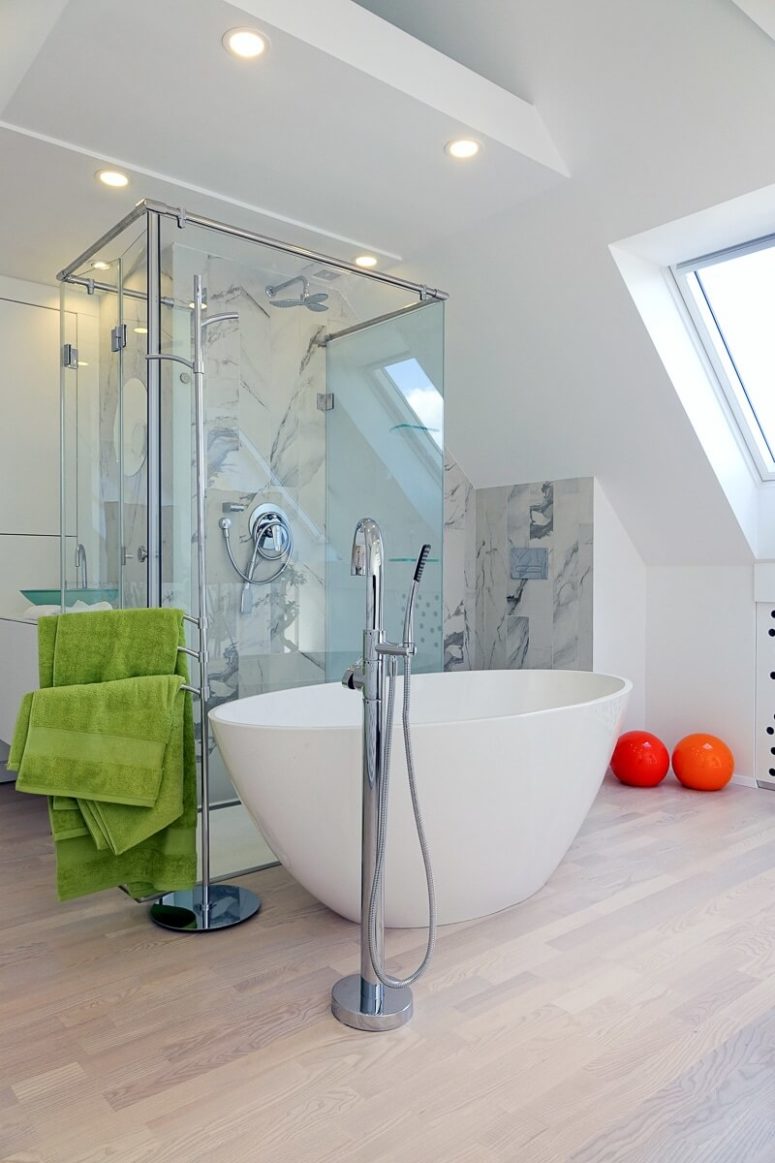 A bathtub in a bedroom is a hot decor trend, this area is clad with marble-inspired tiles