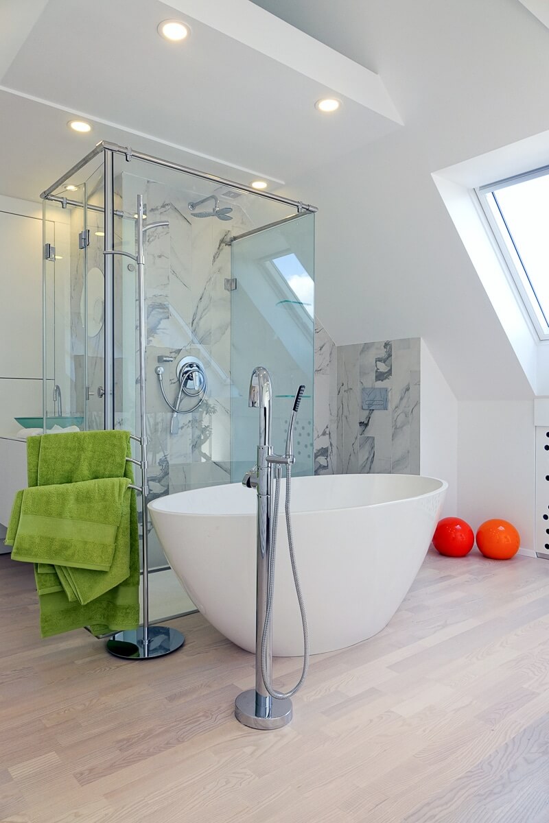 A bathtub in a bedroom is a hot decor trend, this area is clad with marble inspired tiles