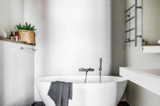 08 The bathroom is small yet very relaxing, with an oval-shaped bathtub and dove grey tiles