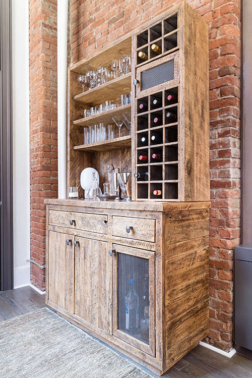 The home bar is made of reclaimed wood, there are open shelves and drawers