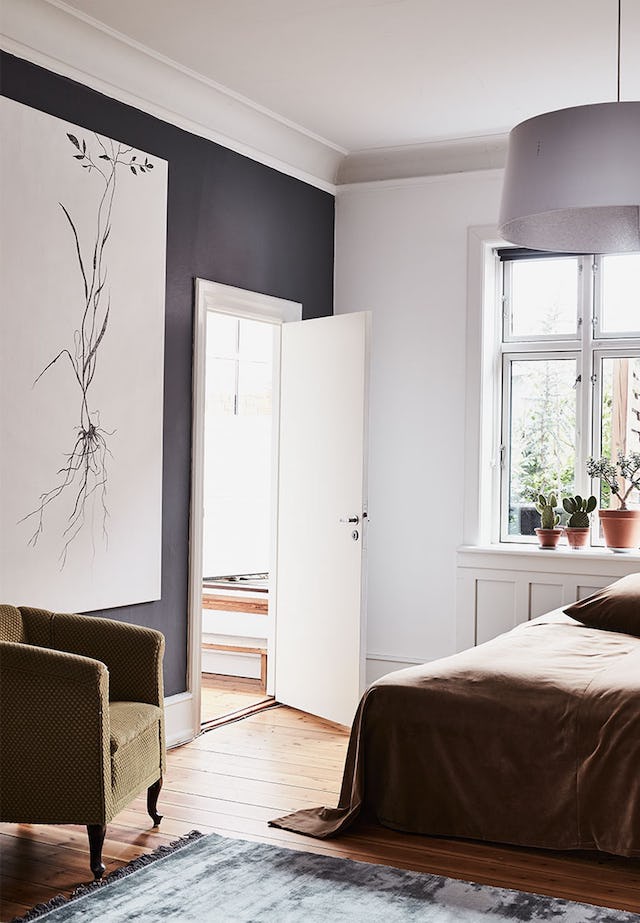 The master bedroom is rather simple and soft, charcoal grey and white, with wooden floors and a cozy mustard colored chair