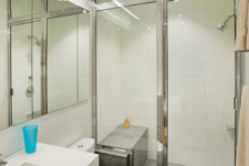 09 The bathroom is done in minimalist style, with a metallic framed shower and white appliances