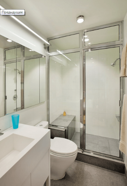 The bathroom is done in minimalist style, with a metallic framed shower and white appliances