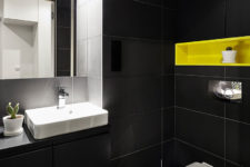 09 The matte black monochromy is broken with a neon yellow built-in shelf over the toilet