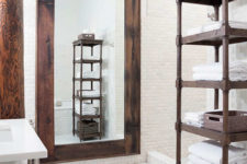 10 The bathroom is clad with white tiles, and the accents are made with dark stained wood and dark metal