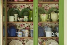 10 a green glass cabinet with colorful floral wallpaper inside for a chic look