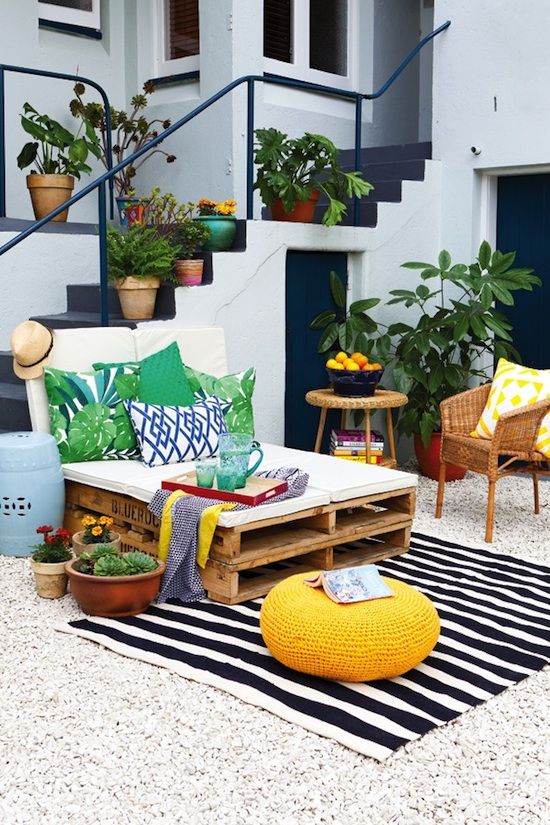bold print pillows and a striped rug add cheer to this outdoor lounge
