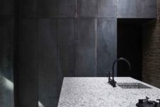 11 a white terrazzo kitchen island looks contrasting in this moody kitchen