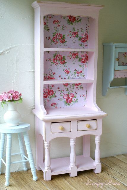 open white cupboard with floral wallpaper inside for a cute shabby chic look