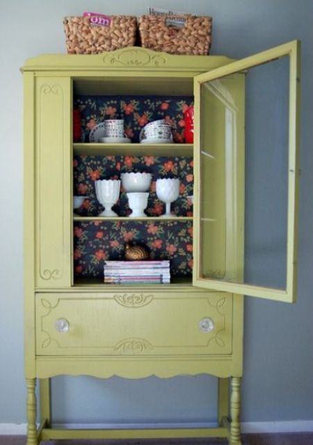 a light mustard color cupboard with dark floral wallpaper for a contrast
