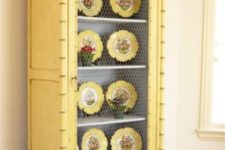 15 a buttermilk cupboard with chicken wire and yellow dishes on display