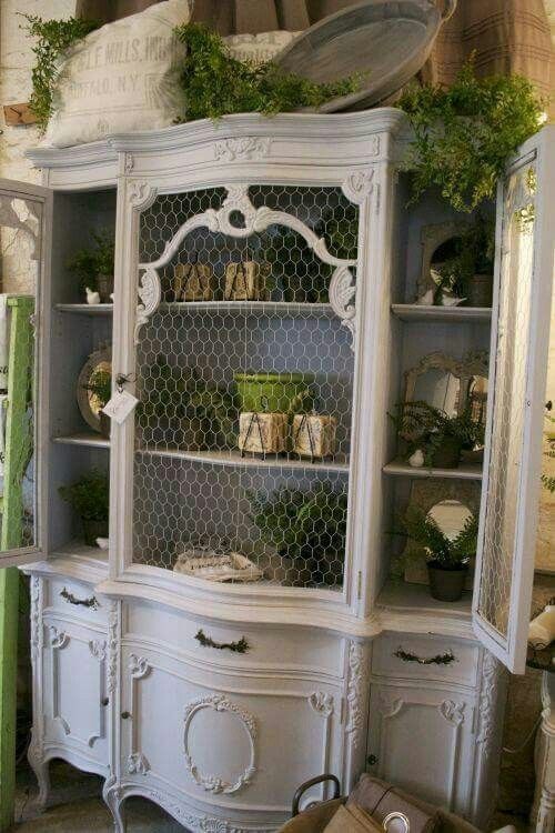 oversized white shabby chic cupboard with chicken wire instead of glass that gives it a unique feel