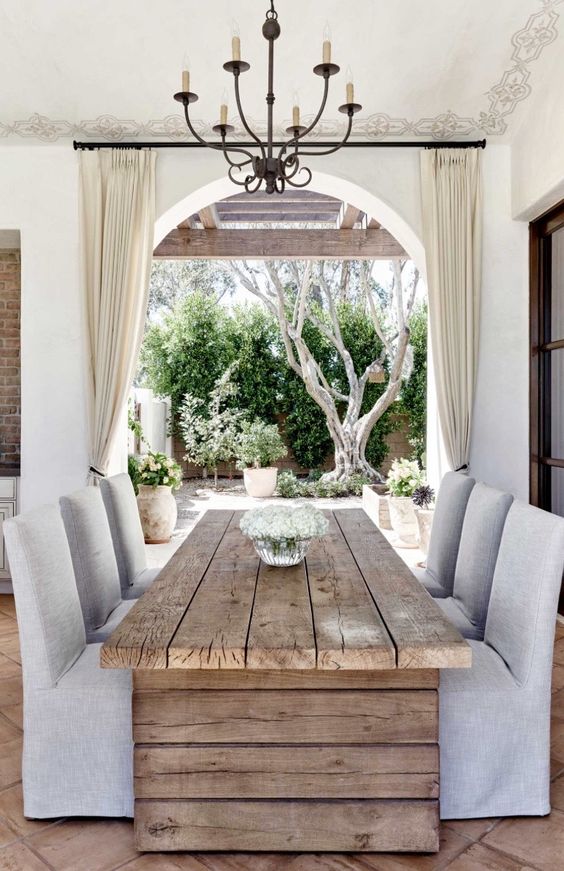 a rustic wooden plank dining table contrasts neutral upholstered chairs