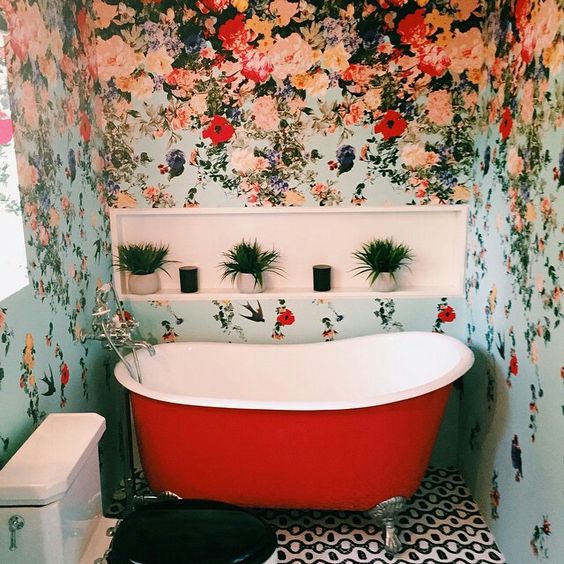 colorful floral wallpaper for a bathroom and a red bathtub that echoes with the walls