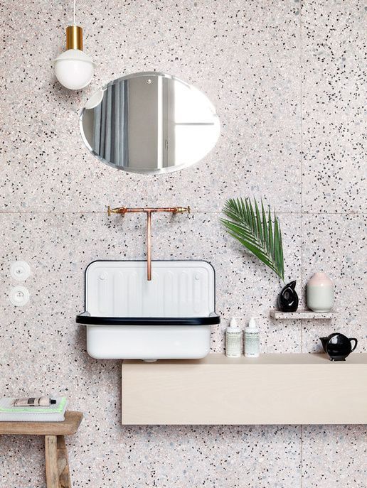 white terrazzo with black dots and copper fixtures for a a chic look