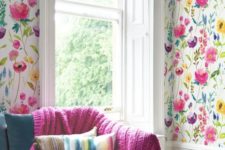 21 colorful floral print wallpaper in the living room and a matching knit fuchsia blanket