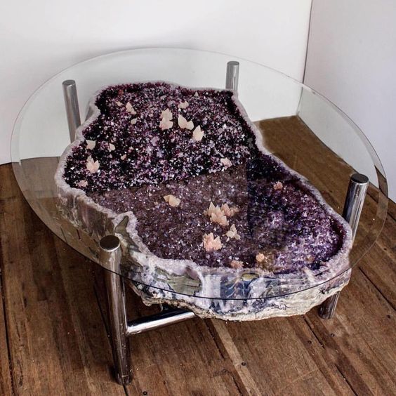 a purple and pink geode coffee table on metal legs and with a glass tabletop
